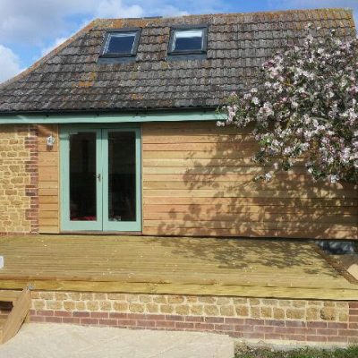 Timber-clad garden room with raised deck