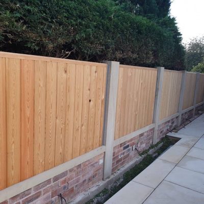Vertical board timber fence on a brick plinth